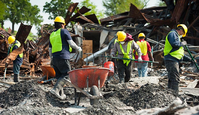 Workers removing debris from collapsed structure